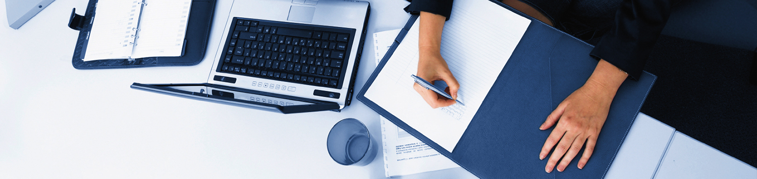 A person taking notes on a desk