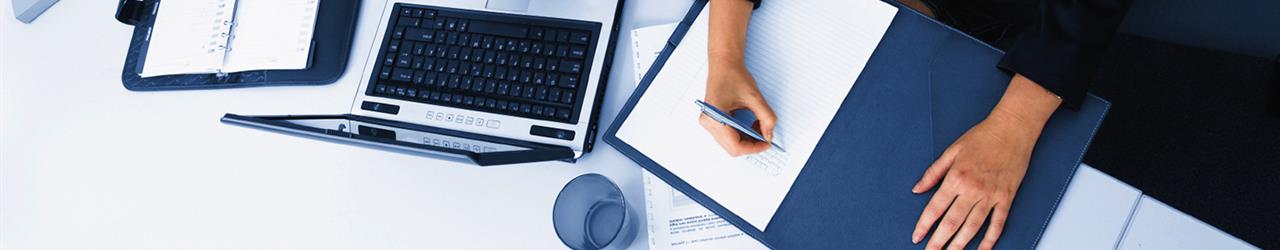 A person taking notes on a desk